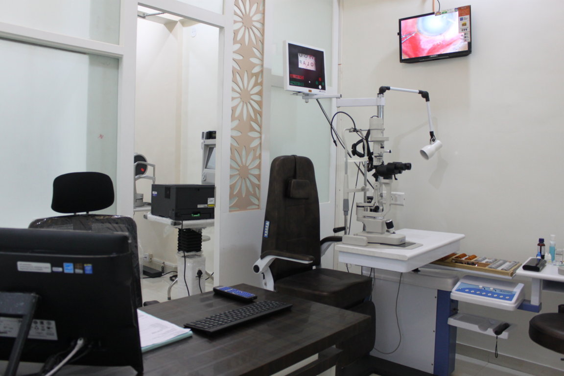Doctor's chamber at Insight Institute showing the slit-lamp examination zone with a pass-through view into the adjoining diagnostic imaging room